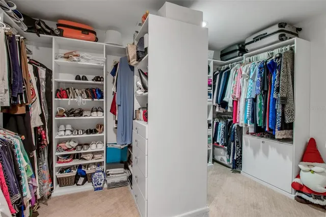 a view of walk in closet with clothes and shoes