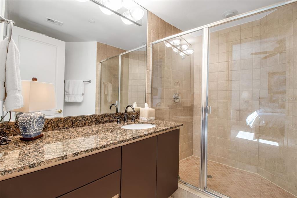 128 Golden Gate Point, Unit 301B Sarasota, FL 34236 - Photo 13 of 34 a bathroom with a granite countertop sink and a mirror