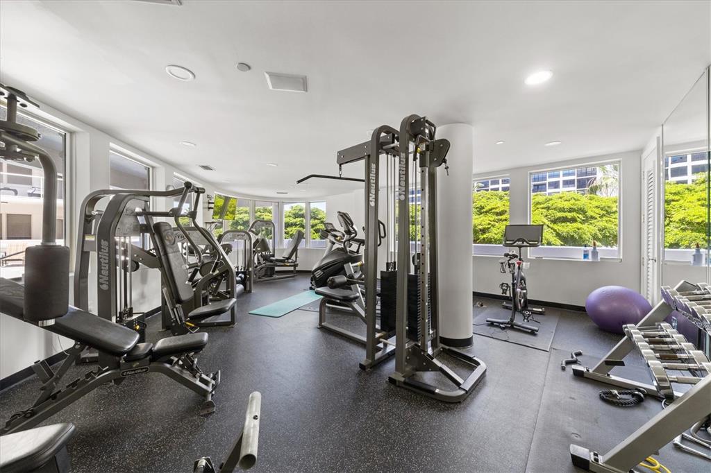 128 Golden Gate Point, Unit 301B Sarasota, FL 34236 - Photo 31 of 34 a room with gym equipment and windows