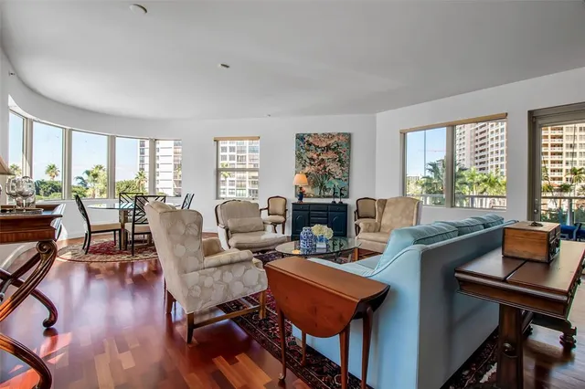 a living room with furniture a large window and wooden floor