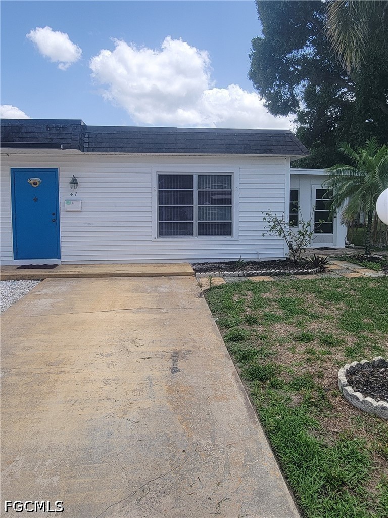 47 Tangelo Court Lehigh Acres, FL 33936 - Photo 1 of 18 a front view of a house with a yard