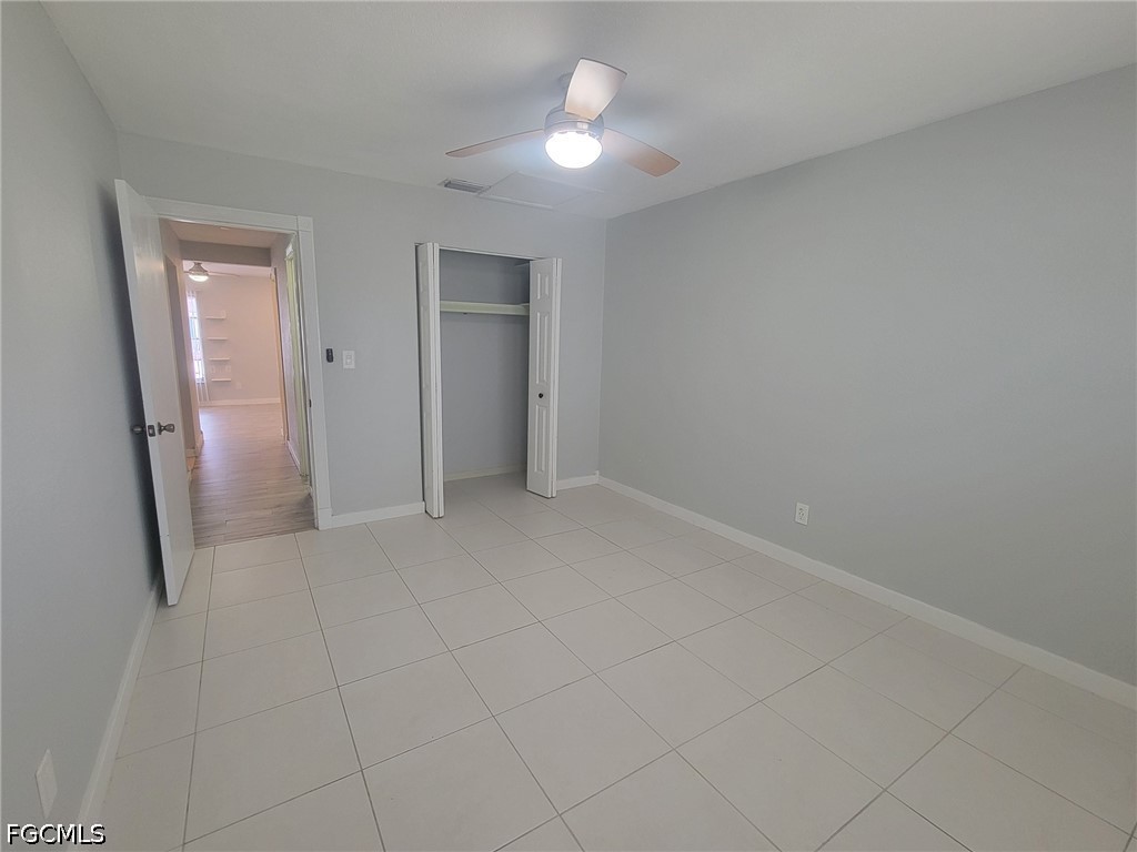 47 Tangelo Court Lehigh Acres, FL 33936 - Photo 13 of 18 an empty room with closet and a chandelier fan
