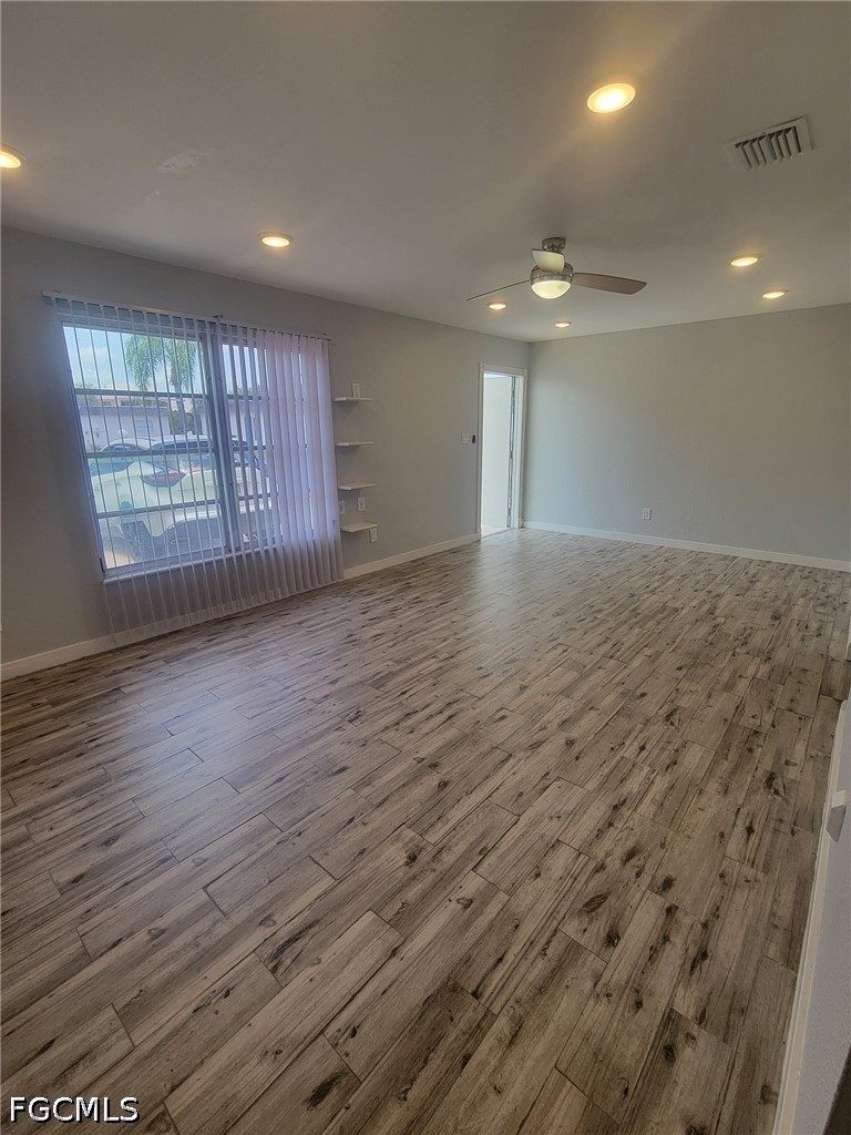 47 Tangelo Court Lehigh Acres, FL 33936 - Photo 4 of 18 a view of an empty room with wooden floor and a window