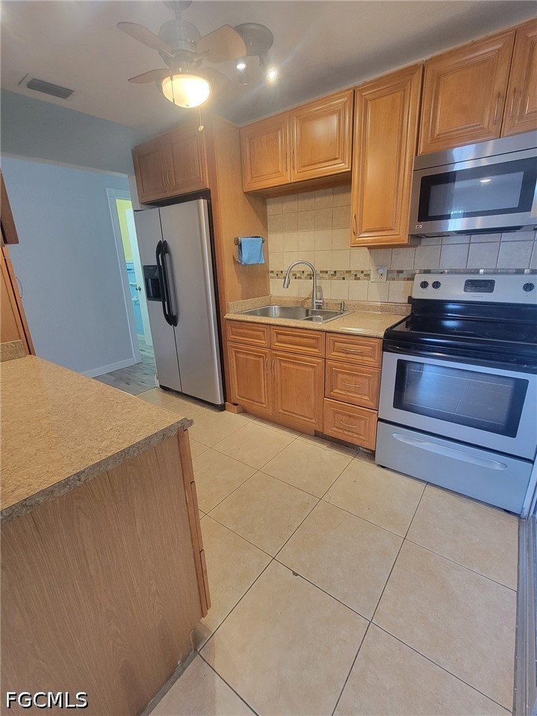 47 Tangelo Court Lehigh Acres, FL 33936 - Photo 6 of 18 a kitchen with a sink a stove top oven and cabinets