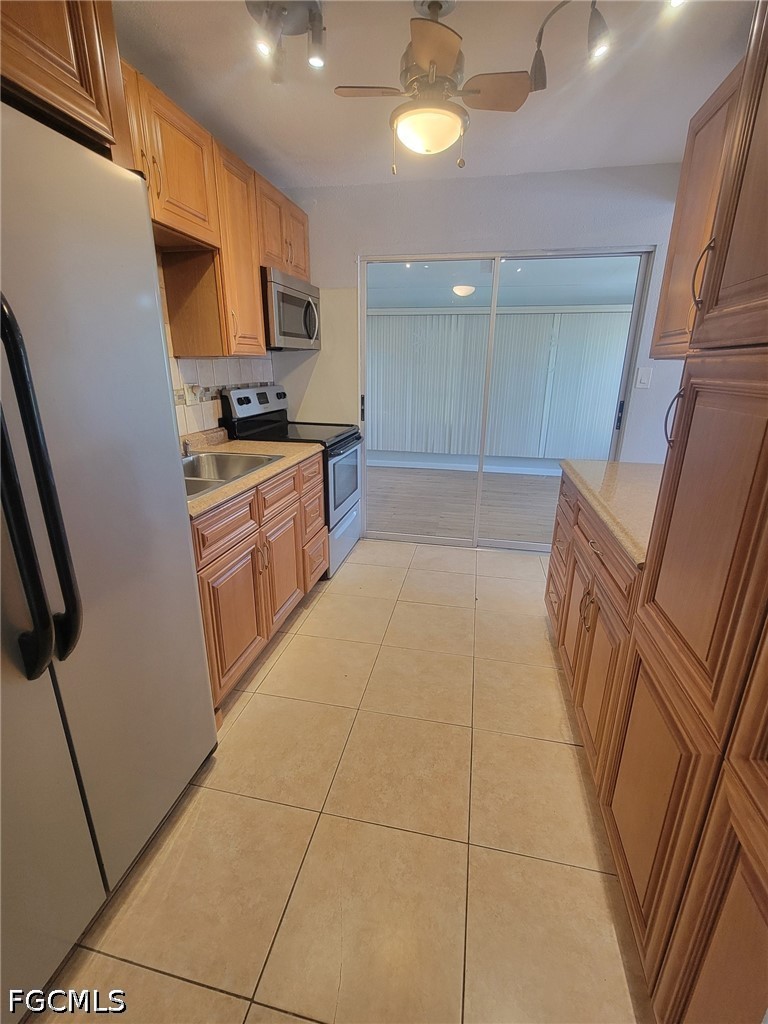 47 Tangelo Court Lehigh Acres, FL 33936 - Photo 7 of 18 a large kitchen with stainless steel appliances a refrigerator and a stove top oven