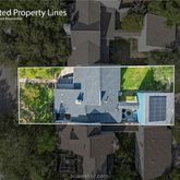 an aerial view of a house with a yard and large trees