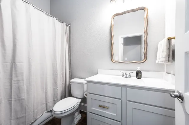 a bathroom with a toilet sink and mirror