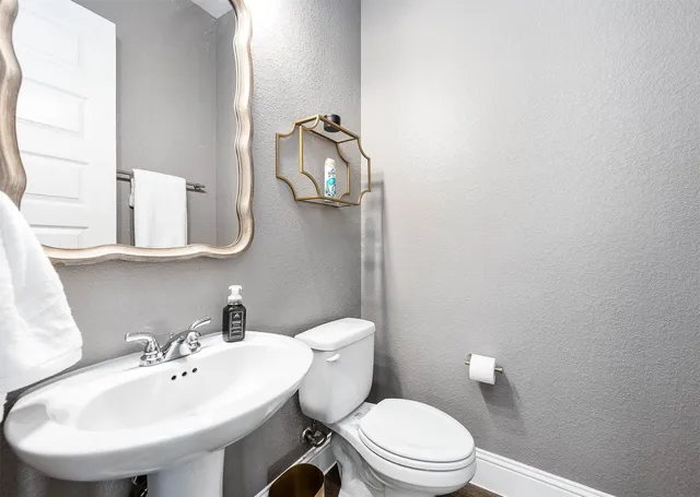 a bathroom with a toilet a sink and mirror