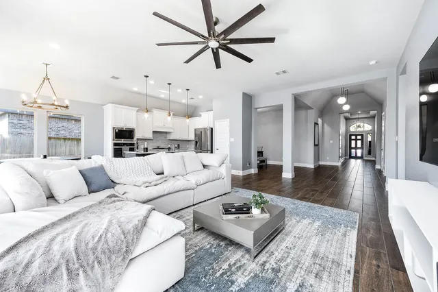a living room with furniture and a view of kitchen