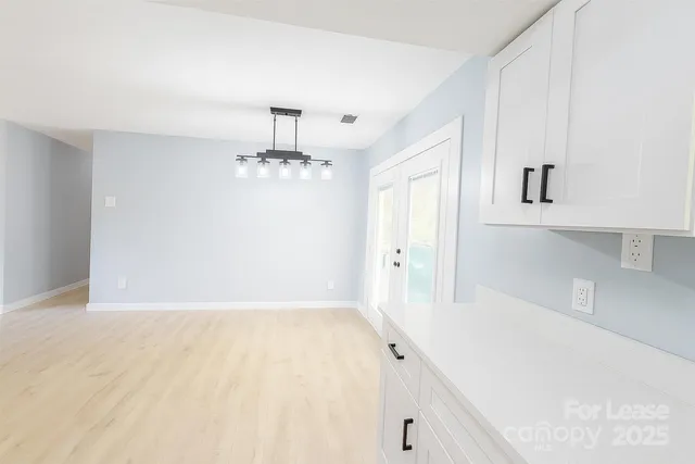 a kitchen with white cabinets appliances a sink and a window