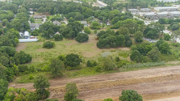an aerial view of residential houses with outdoor space and trees