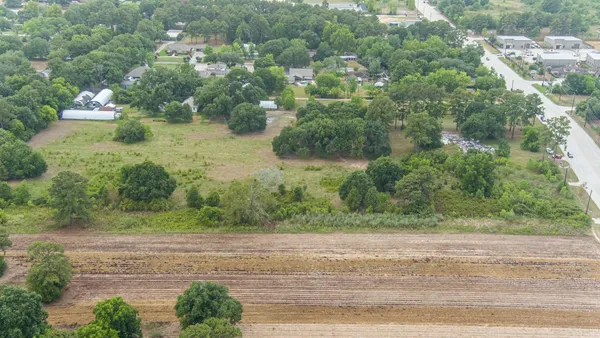 an aerial view of residential houses with outdoor space and trees