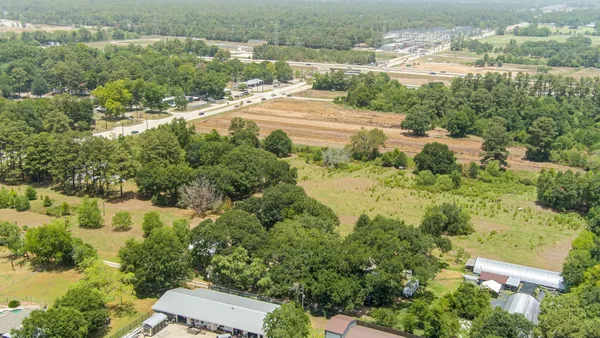 an aerial view of residential houses with outdoor space and trees