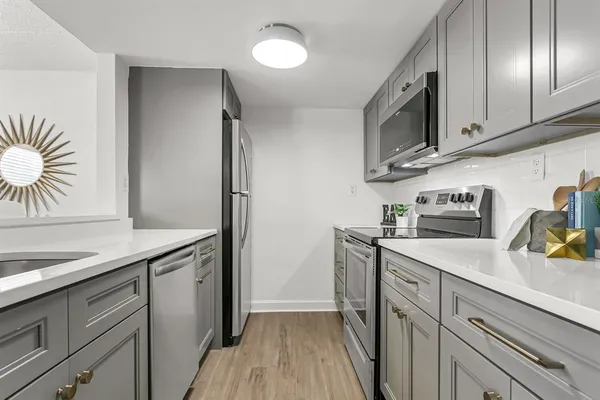 a kitchen with stainless steel appliances granite countertop a sink stove and microwave