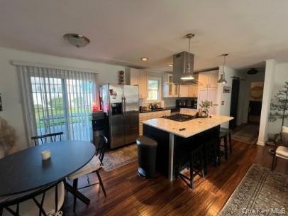 1241 Stony Brook Road Lake Grove, NY 11755 - Photo 3 of 10 a kitchen with a stove a refrigerator a sink dishwasher with a dining table and chairs with wooden floor