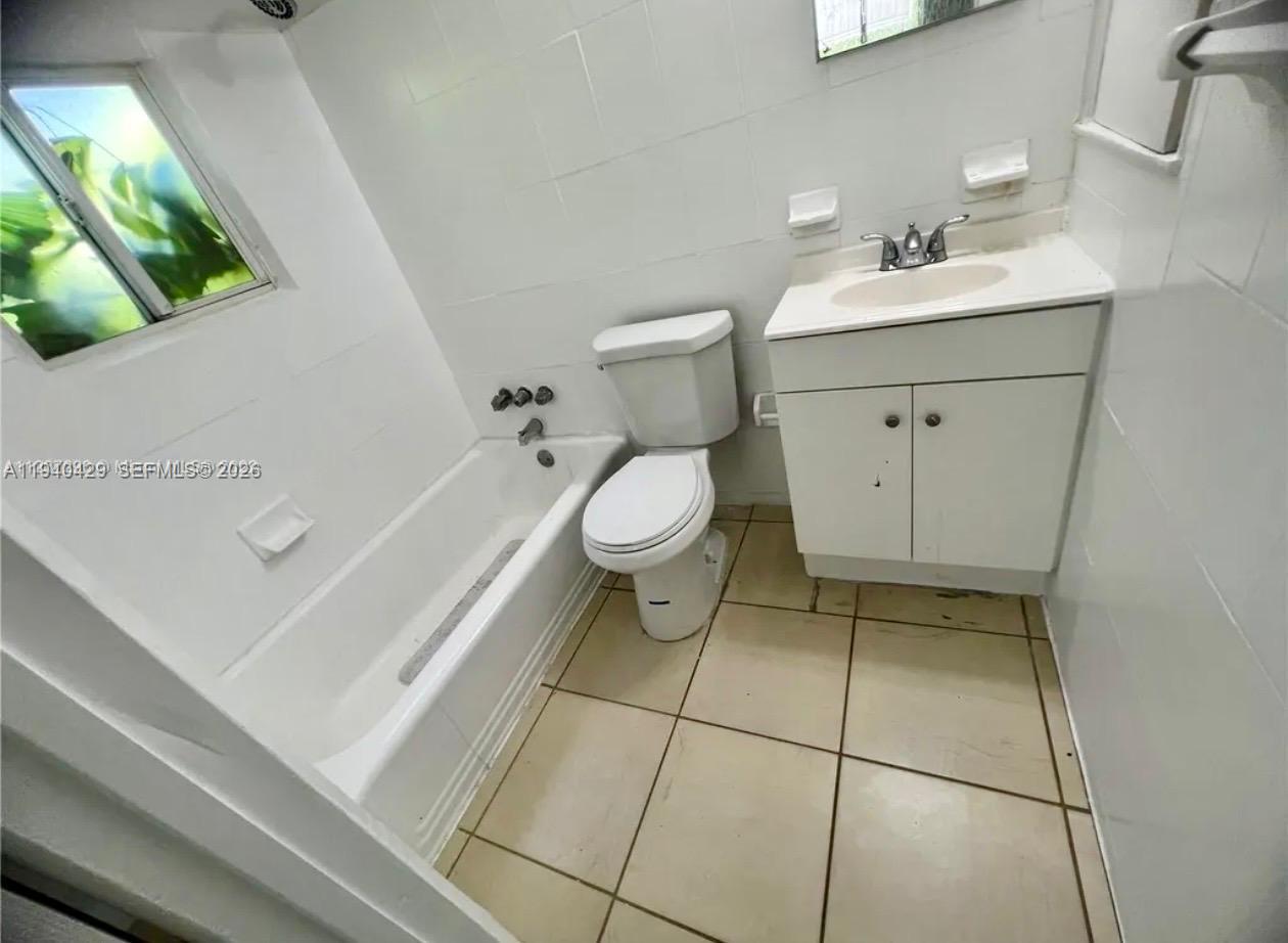 128 Northwest 53rd Street Miami, FL 33127 - Photo 14 of 22 a bathroom with a sink a toilet and vanity