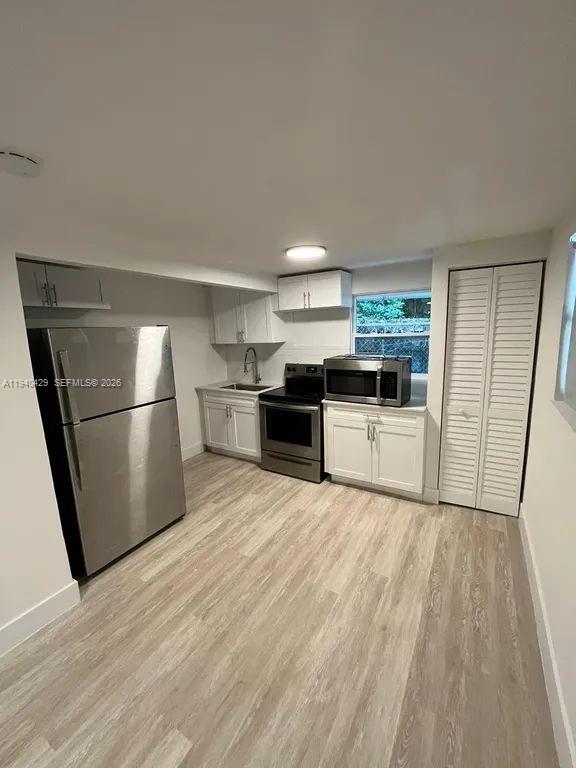 128 Northwest 53rd Street Miami, FL 33127 - Photo 10 of 22 a kitchen with a refrigerator a stove top oven and a refrigerator