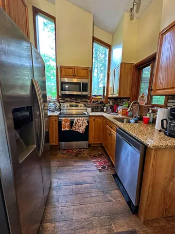 a kitchen with stainless steel appliances granite countertop a sink stove and refrigerator