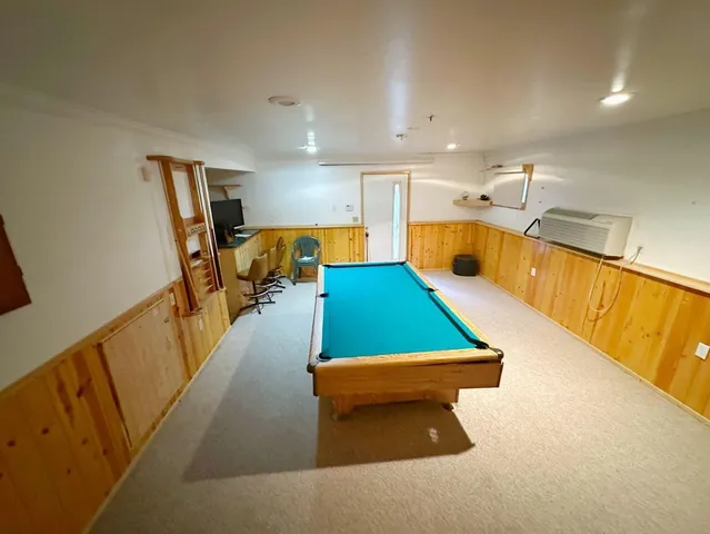 a room with pool table and windows