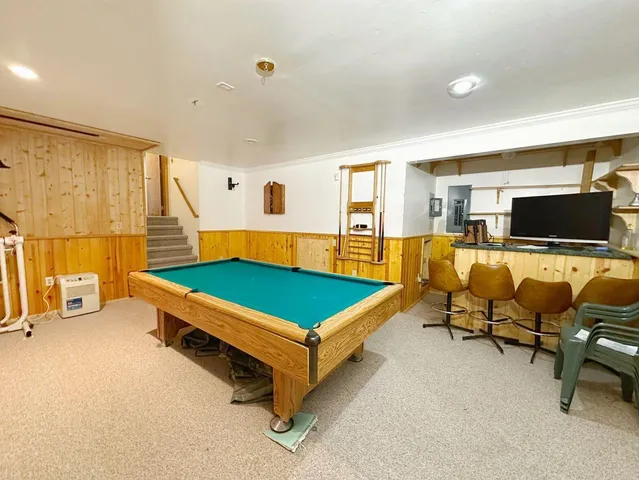a room with furniture pool table and flat screen tv