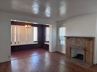 1821 9th Street, Unit B Wichita Falls, TX 76301 - Photo 4 of 14 an empty room with wooden floor fireplace and windows