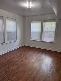 1821 9th Street, Unit B Wichita Falls, TX 76301 - Photo 5 of 14 an empty room with wooden floor and windows