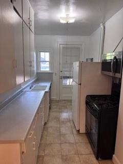 1821 9th Street, Unit B Wichita Falls, TX 76301 - Photo 8 of 14 a kitchen with stainless steel appliances granite countertop a refrigerator and a stove