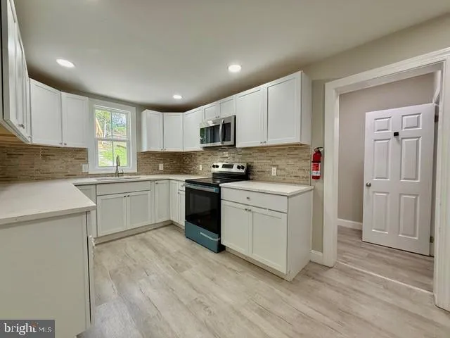 a kitchen with granite countertop white cabinets and white appliances