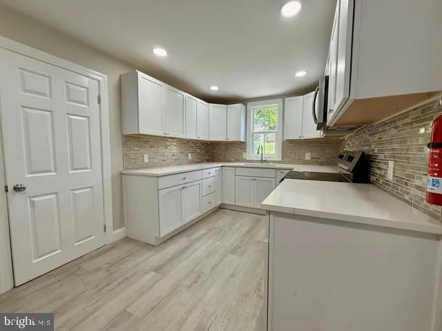a view of a kitchen with a sink cabinets and wooden floor