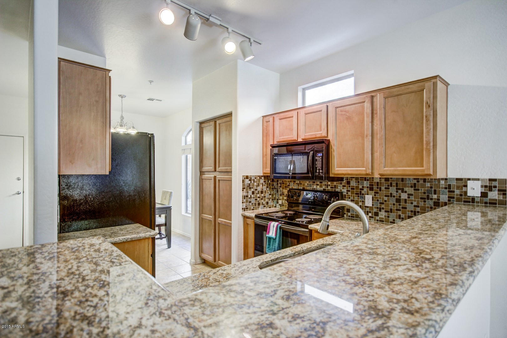 2150 East Bell Road, Unit 1060 Phoenix, AZ 85022 - Photo 5 of 25 a view of a kitchen with kitchen island granite countertop a refrigerator and a sink
