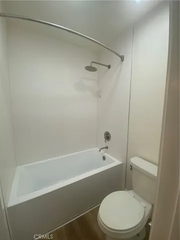 a white toilet and tub sitting next to a bathroom sink