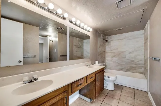 a bathroom with a double vanity sink mirror and bathtub
