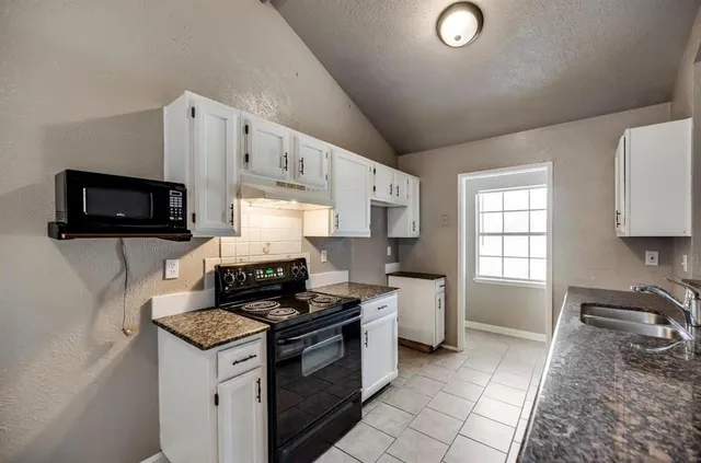 a kitchen that has a sink and a stove top oven