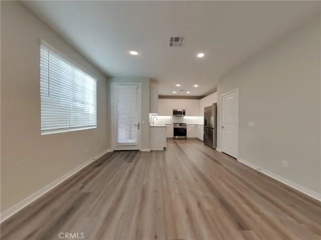a view of empty room with wooden floor