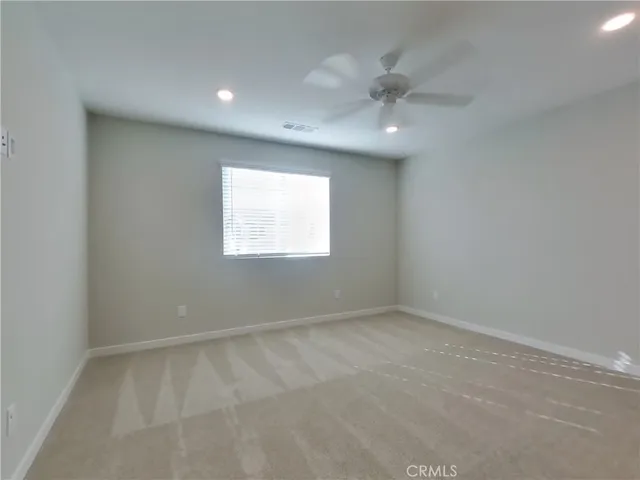 an empty room with a window and a chandelier fan