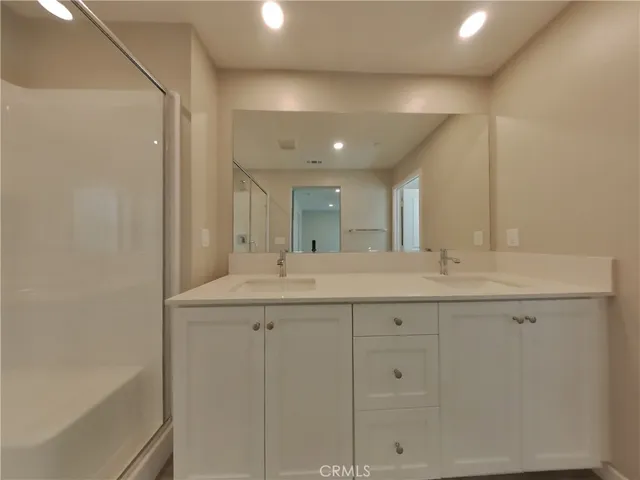 a bathroom with double sink and a mirror