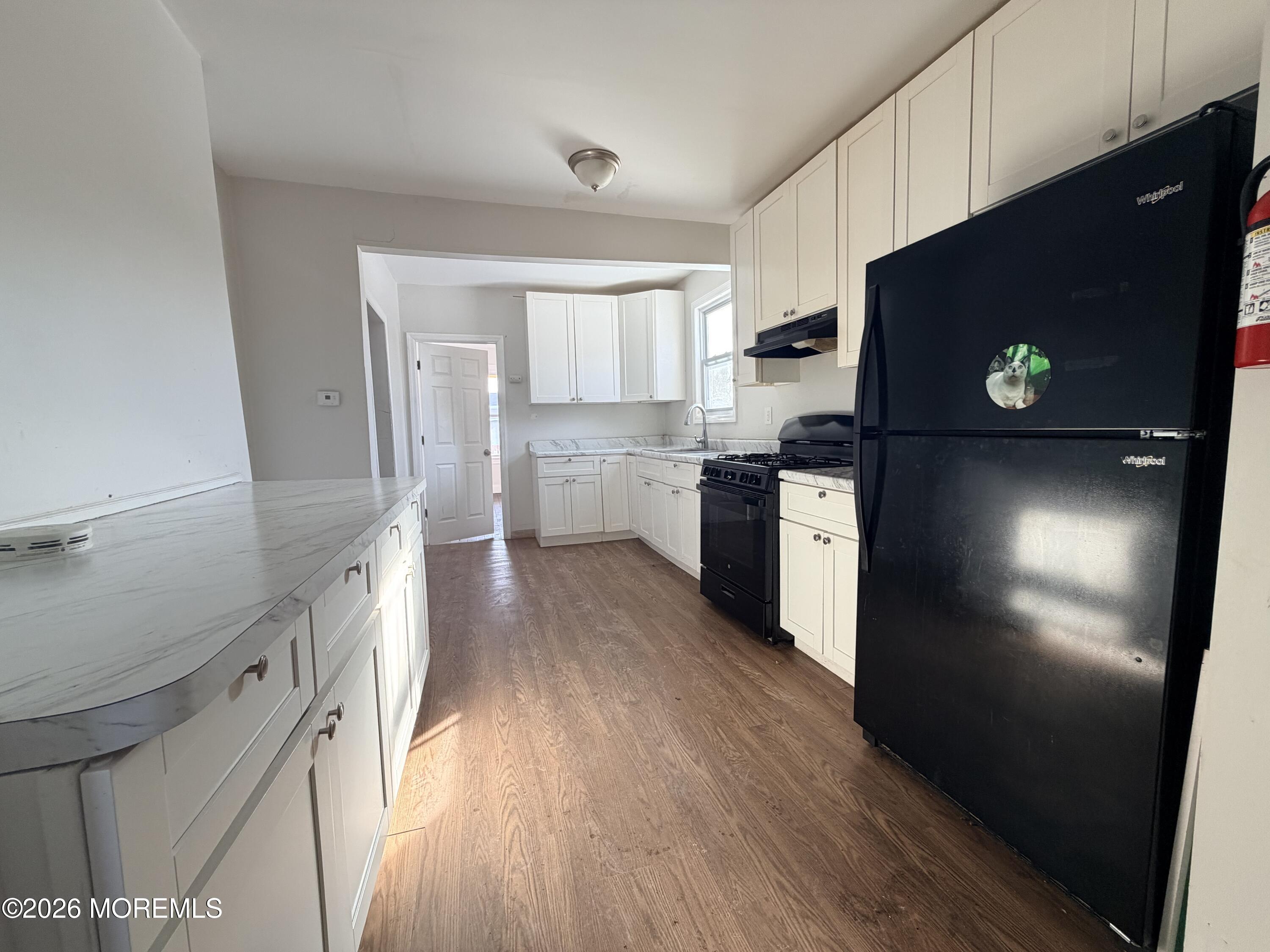 101-103 Ridge Avenue Asbury Park, NJ 07712 - Photo 5 of 11 a kitchen with a refrigerator and a stove top oven