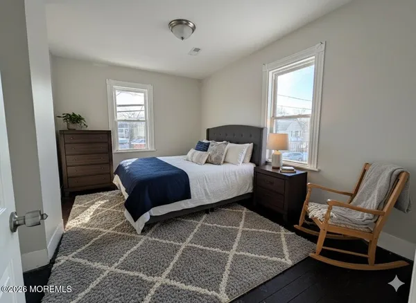 a bedroom with a bed and windows