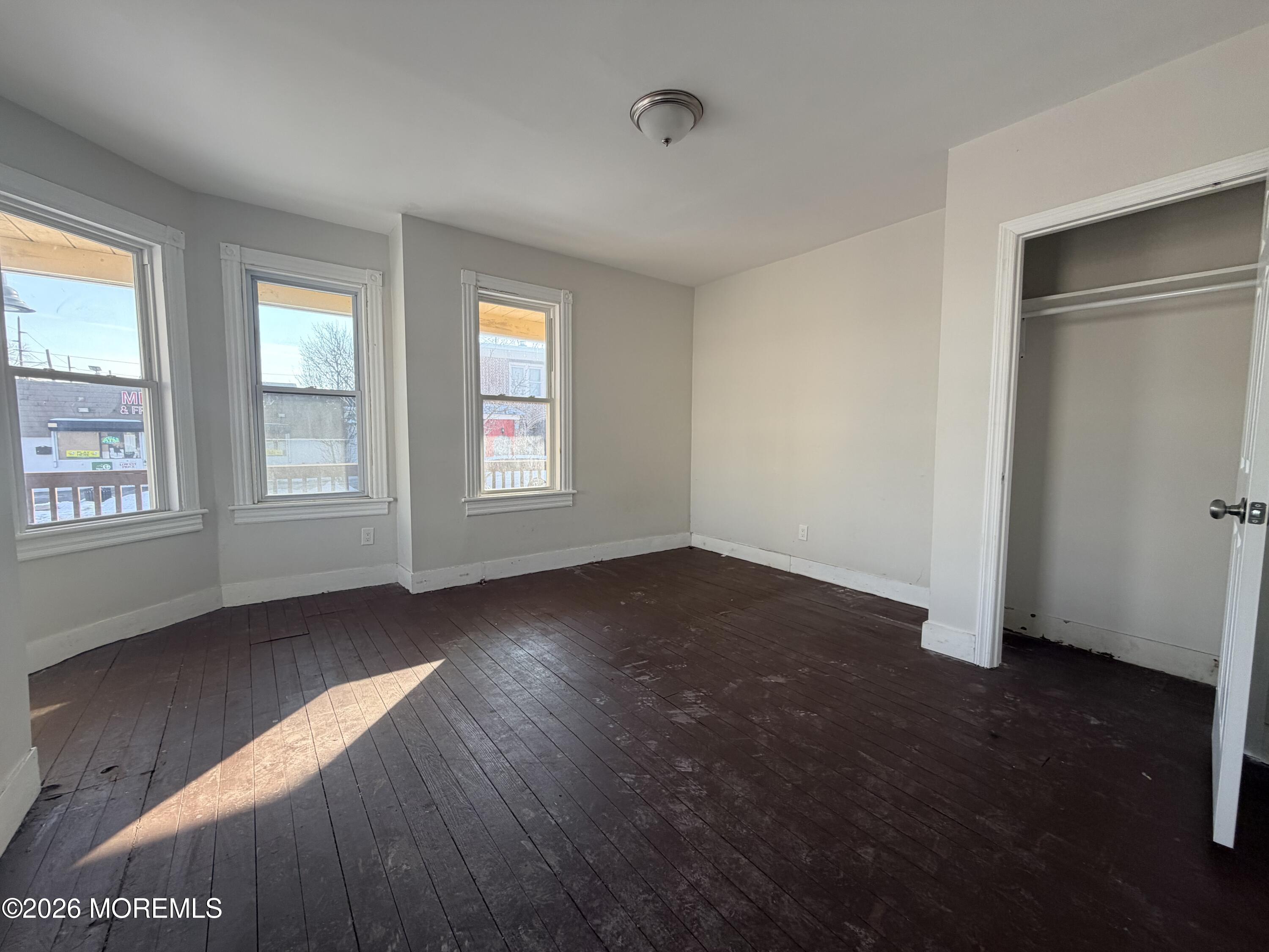 101-103 Ridge Avenue Asbury Park, NJ 07712 - Photo 9 of 11 an empty room with wooden floor and windows