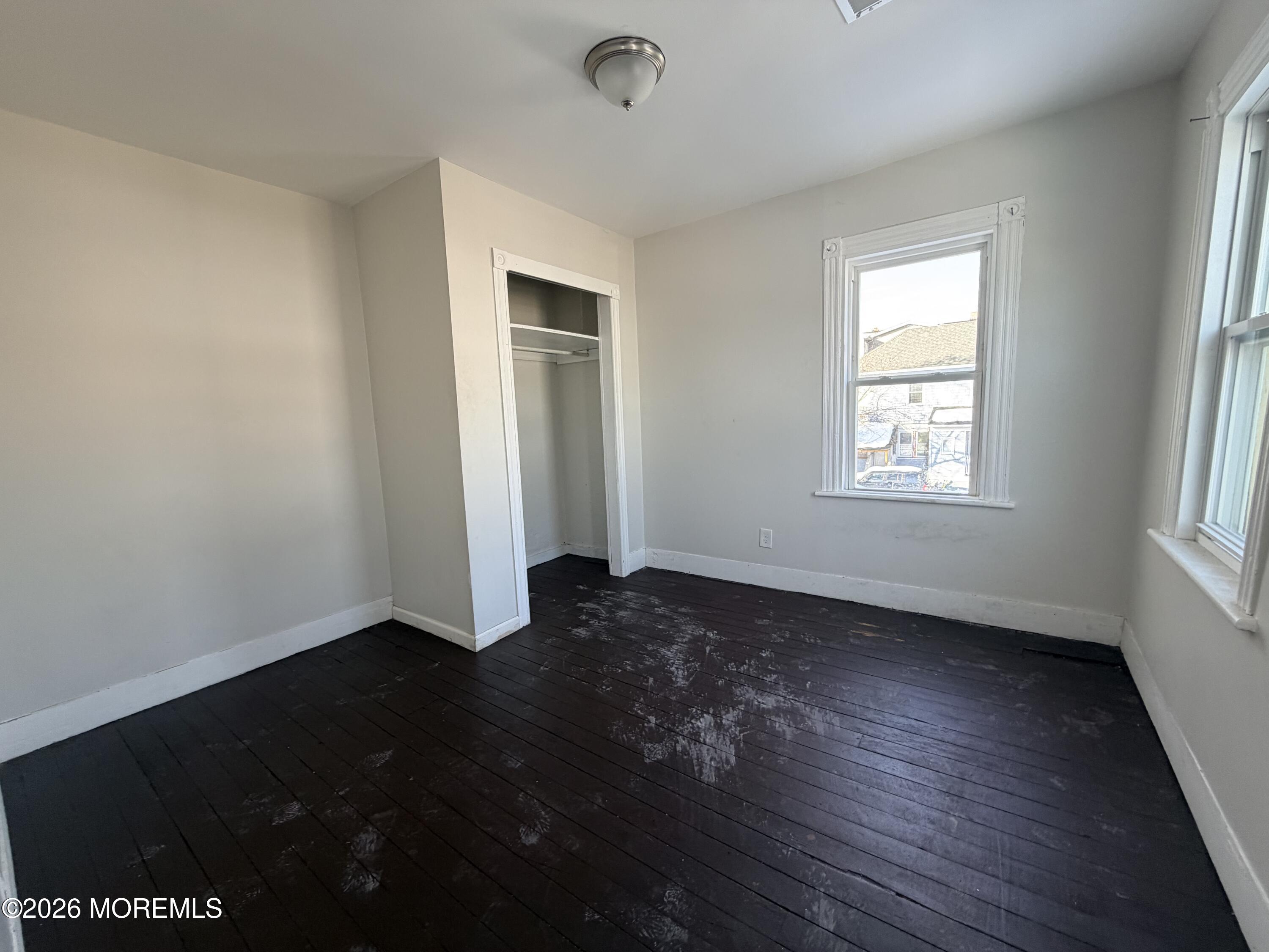 101-103 Ridge Avenue Asbury Park, NJ 07712 - Photo 10 of 11 an empty room with wooden floor and windows