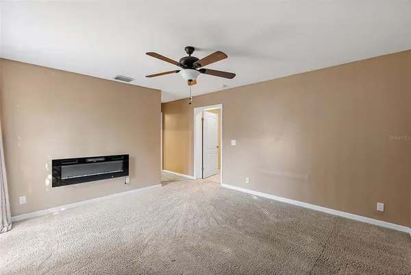 a view of a big room with wooden floor and a ceiling fan