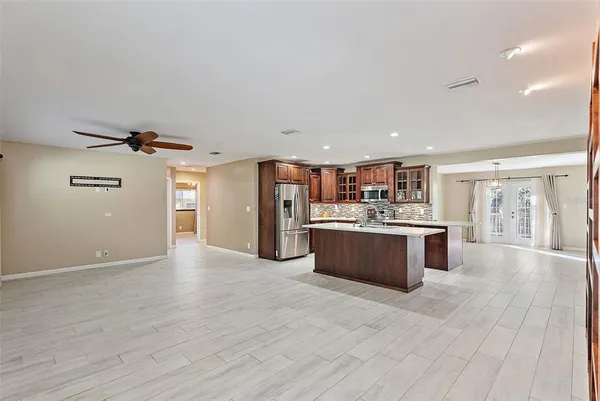 a large kitchen with stainless steel appliances kitchen island a large counter top and a wooden floors