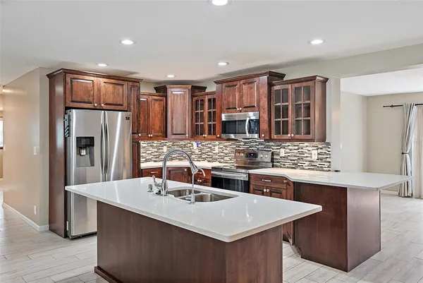 a kitchen with stainless steel appliances granite countertop a sink stove and refrigerator