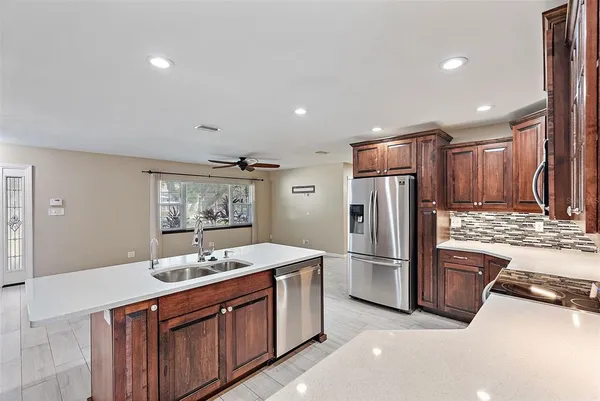 a kitchen with stainless steel appliances granite countertop a sink stove and refrigerator