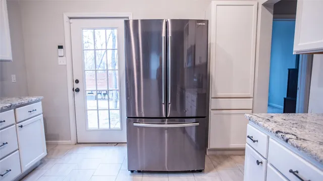 a kitchen with kitchen island granite countertop wooden cabinets and white appliances