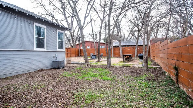 a view of a house with backyard and a tree
