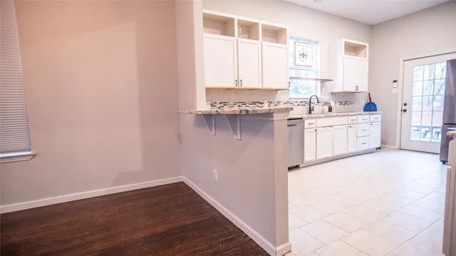 a kitchen with granite countertop white cabinets and white appliances