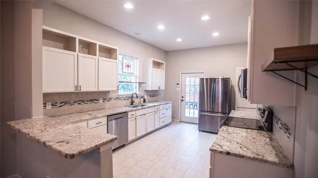 a large kitchen with kitchen island granite countertop a stove and a refrigerator