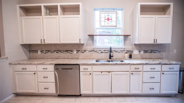 a kitchen with granite countertop a sink cabinets and a window