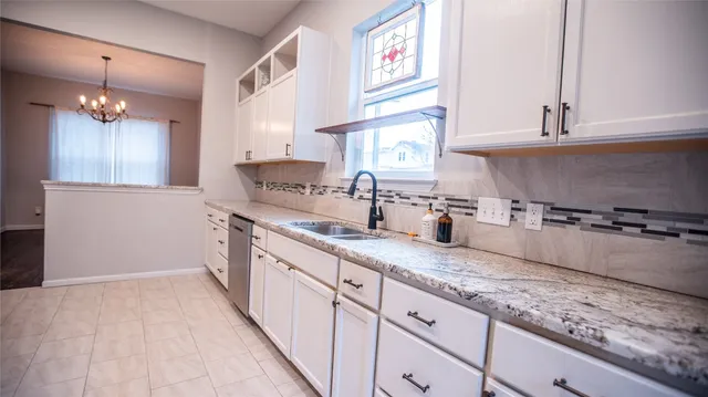 a kitchen with granite countertop a sink stainless steel appliances and cabinets
